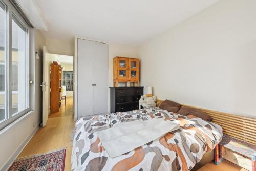 une chambre avec un lit et une grande fenêtre dans l'établissement La Demeure - Maison de 180m2 à Porte de Versailles, à Paris