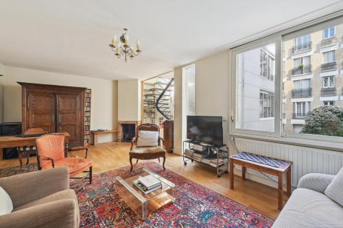un salon avec un canapé et une télévision dans l'établissement La Demeure - Maison de 180m2 à Porte de Versailles, à Paris