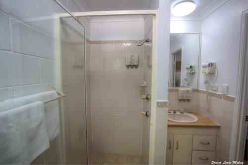 a bathroom with a glass shower and a sink at The Queens Gladstone in Gladstone