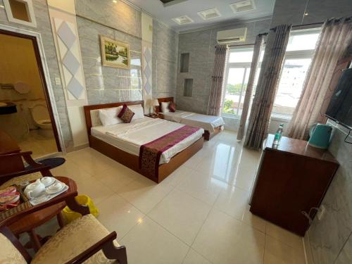 a hotel room with a bed and a television at Hồng Nhung Hotel Kiên Giang in Rach Gia