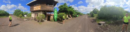 two people standing on a dirt road next to a building at El Pajas in Puerto Velasco Ibarra
