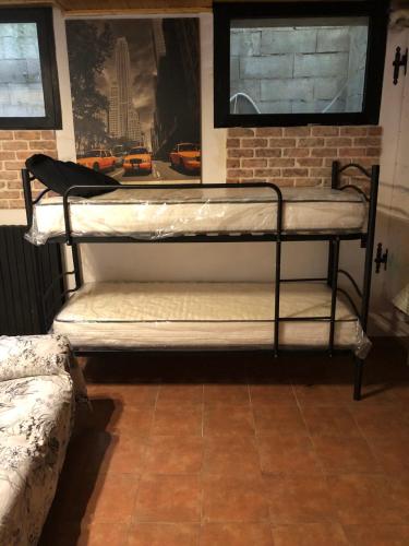 een metalen stapelbed in een kamer met een bakstenen muur bij Bazzini House in Carnate