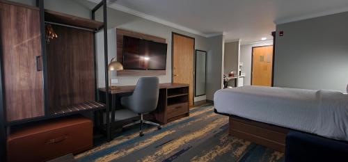 um quarto com uma cama e uma secretária com um computador em La Quinta Inn & Suites by Wyndham Yakima Downtown em Yakima