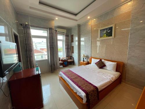 a hotel room with a bed and a television at Hồng Nhung Hotel Kiên Giang in Rach Gia