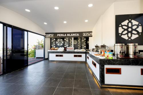 a kitchen with white counters and a counter top at Perla Blanca Hotel in Trabzon