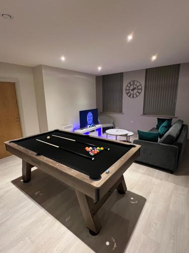 a living room with a pool table and a couch at Spacious Modern Apartment - Leeds City Centre in Leeds