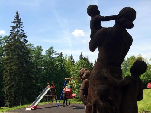 a statue of a man holding a child on a playground at Sonnenhof in Bad Elster