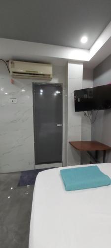 a room with a bed with a door and a television at HYTON GRAND in Urapakkam