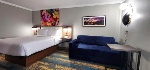 a hotel room with a bed and a blue couch at La Quinta Inn & Suites by Wyndham Yakima Downtown in Yakima