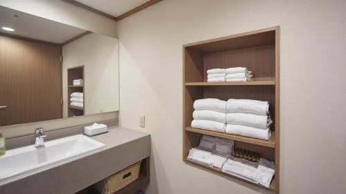 a bathroom with a sink and a mirror and towels at Sunshine City Prince Hotel Ikebukuro Tokyo in Tokyo