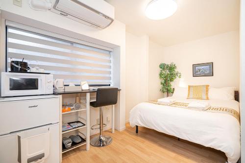 a small bedroom with a bed and a microwave at 夏5GWifi TokyoDome皇居1km〜 RoofGarden 上野秋葉原銀座東京2km～都心 in Tokyo