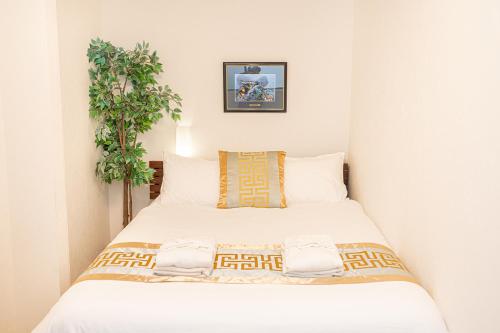 a bedroom with a white bed with a plant at 夏5GWifi TokyoDome皇居1km〜 RoofGarden 上野秋葉原銀座東京2km～都心 in Tokyo