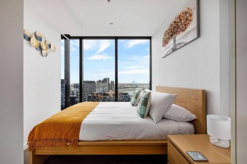 a bedroom with a bed with a large window at The Spencer Suite - Cityscape Panorama with Pool in Melbourne