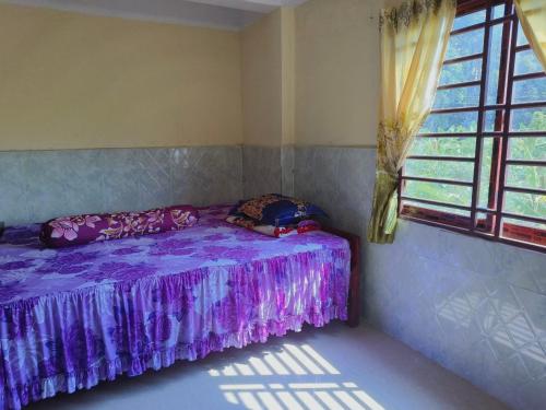 a purple bed in a room with a window at Melop Koki Homestay 7 in Krong Kracheh