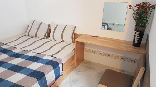 Schlafzimmer mit einem Bett, einem Schreibtisch und einem Spiegel in der Unterkunft Hoa Lan Motel & Homestay in Giồng Tú Ðiền