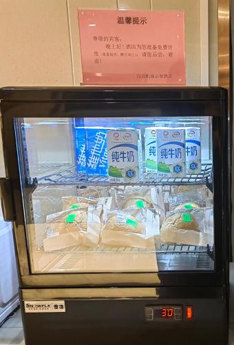 a refrigerator with some food inside of it at Guangzhou Baiyun Airport Yunzhi Hotel near Terminal One - Complimentary Shuttle Bus between hotel to Canton Fair Complex during Canton Fair in Guangzhou