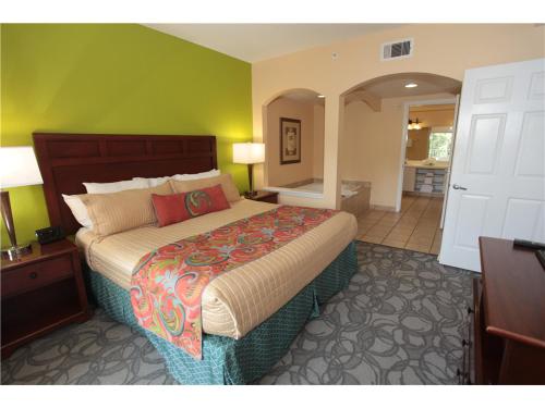 1 dormitorio con 1 cama grande y baño en Be Our Guest, en Orlando