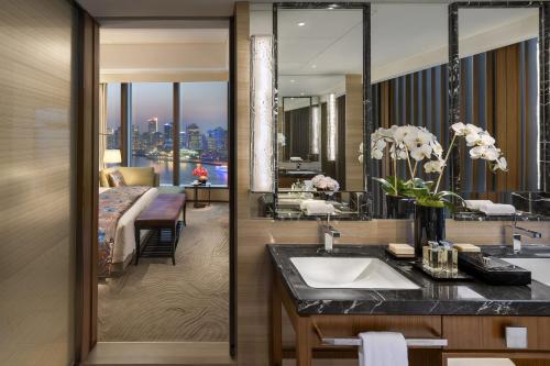 a bathroom with a sink and a bedroom at Mandarin Oriental Pudong, Shanghai in Shanghai