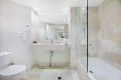 a bathroom with a toilet and a sink and a shower at Cosy 2-Bed Central Studio Apartment With Views in Gold Coast