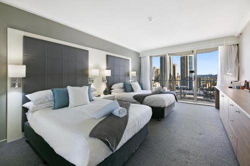 a hotel room with two beds and a large window at Cosy 2-Bed Central Studio Apartment With Views in Gold Coast