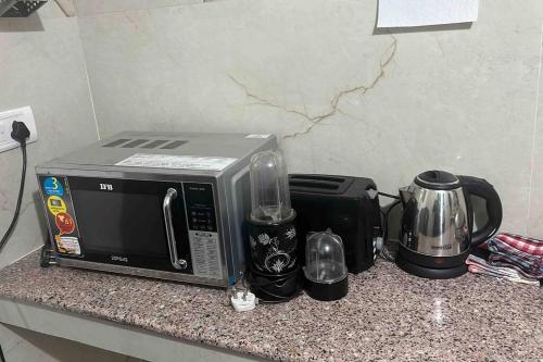 a microwave sitting on a counter next to a coffee maker at Authentic Indian Culture in Panchkula