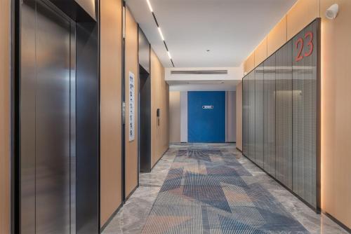 a corridor in a building with doors and a tile floor at Holiday Inn Express Changsha Yuhua, an IHG Hotel in Changsha