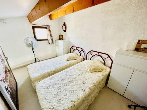 - une chambre avec 2 lits et un ventilateur dans l'établissement Villa Cap d'Agde : Plage à pied, piscine, parking, terrasse - FR-1-723-140, au Cap d'Agde