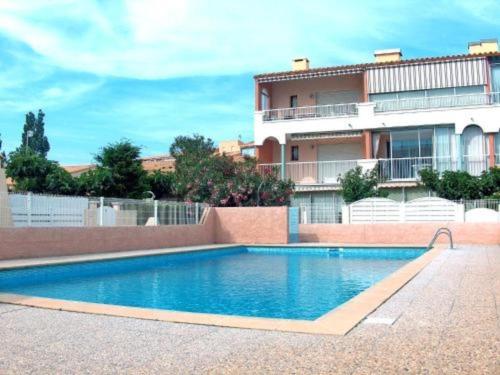 une piscine devant un immeuble dans l'établissement Villa Cap d'Agde : Plage à pied, piscine, parking, terrasse - FR-1-723-140, au Cap d'Agde