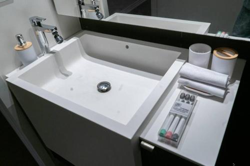 La salle de bains est pourvue d'un lavabo blanc. dans l'établissement Beautiful and Central 3 Bedroom Condo with Parking, à Toronto