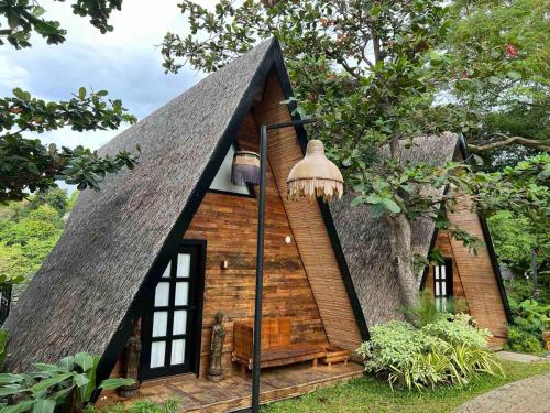 a small house with a thatched roof at Nawa Wellness in Calatagan