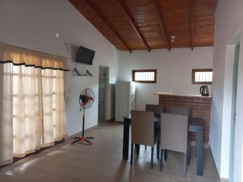 une cuisine et une salle à manger avec une table et un réfrigérateur dans l'établissement Casa cerca del centro con cochera, à Posadas