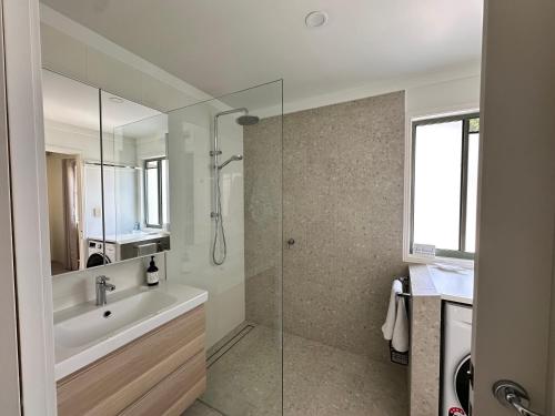une salle de bain avec un lavabo et une douche en verre dans l'établissement THE DUNES + 100M TO BEACH + POOL + EXCEPTIONAL LOCATION, à Point Lookout