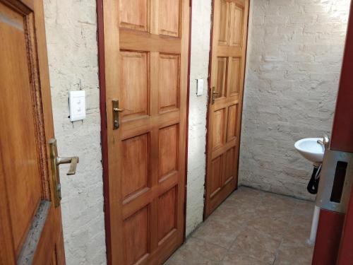 un bagno con 2 porte in legno e un lavandino di Bungalow - C - by Salbu a Pinedene