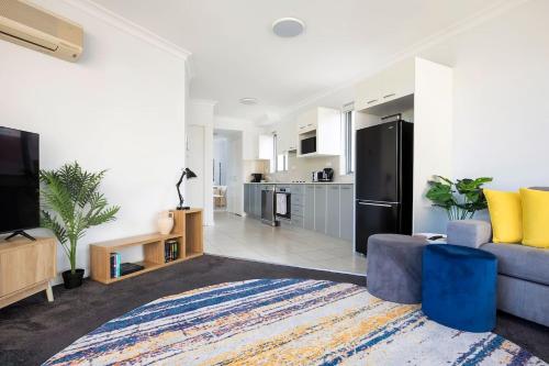 a living room with a couch and a kitchen at The Earl - Potts Point Paradise with Sydney Views in Sydney