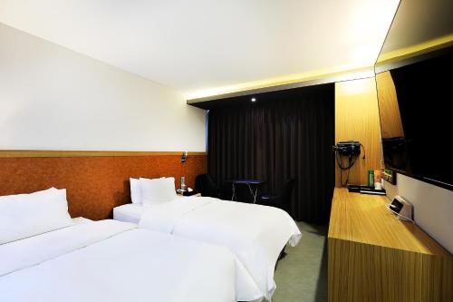 a hotel room with two beds and a television at CS Avenue Tourist Hotel in Seoul