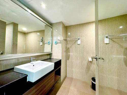 a bathroom with a sink and a shower at Ramada Sukhumvit Soi Eleven in Bangkok