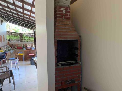 a living room with a brick fireplace in a house at Bela casa de praia beira mar in Feliz Deserto