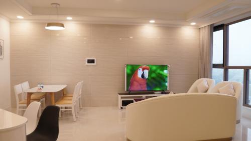 a living room with a television and a table with chairs at Starlake Daewoo Deluxe Apartment Managed by Anstay in Hanoi
