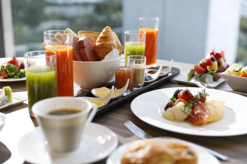 a table with plates of breakfast foods and drinks at Palace Hotel Omiya in Saitama