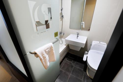 a bathroom with a white toilet and a sink at CS Avenue Tourist Hotel in Seoul