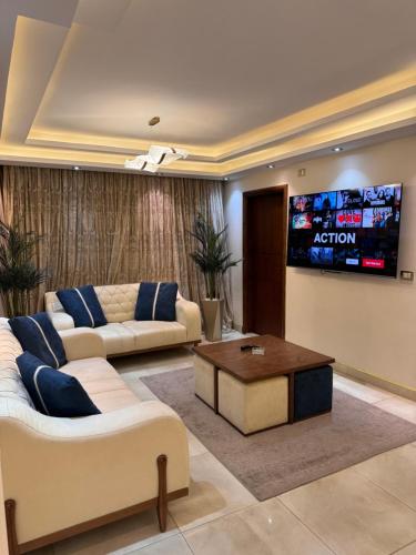 een woonkamer met 2 banken en een flatscreen-tv bij Royal Stay in Caïro