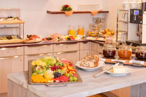 a kitchen with a table filled with fruit and bread at Hotel Garni Regina in Oberstdorf