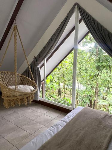 ein Schlafzimmer mit einem Schaukelbett und einem Fenster in der Unterkunft Rossélodgevillas in Fortuna