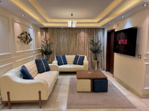 een woonkamer met 2 banken en een flatscreen-tv bij Royal Stay in Caïro