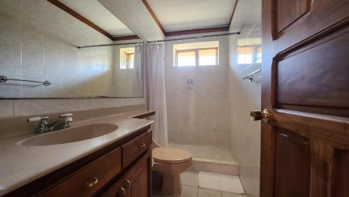 y baño con lavabo, aseo y ducha. en La Casa de Cariari Al Golf, en Heredia