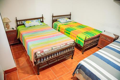 dos camas sentadas una al lado de la otra en una habitación en Blue Beach House Chicama - Habitaciones, en Puerto Chicama