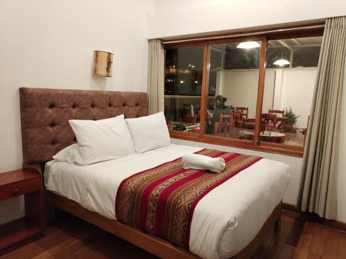 1 dormitorio con 1 cama grande y ventana en Paqarina San Blas en Cusco