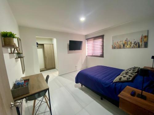 a bedroom with a blue bed and a desk in it at Cómodo Loft Tequis. Facturamos in San Luis Potosí