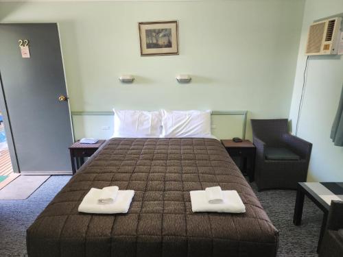 Una habitación de hotel con una cama con dos toallas. en Lake Forbes Motel, en Forbes
