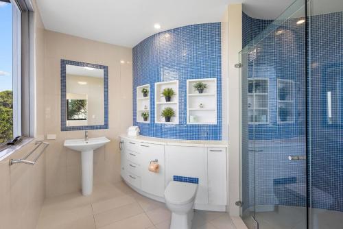 a bathroom with a toilet sink and a shower at Saltwater Beach House in Yaroomba